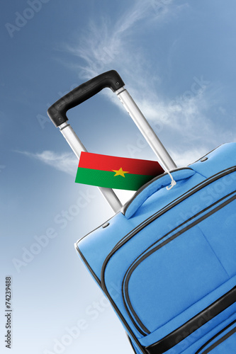 Destination Burkina Faso. Blue suitcase with flag.
