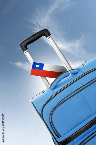Destination Chile. Blue suitcase with flag.