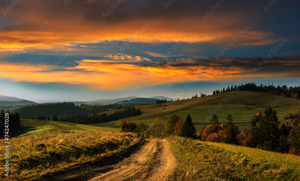 Wide road in the Carpathian Mountains at sunset.