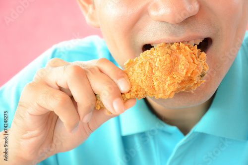 A man eating fried chicken leg or drumstick