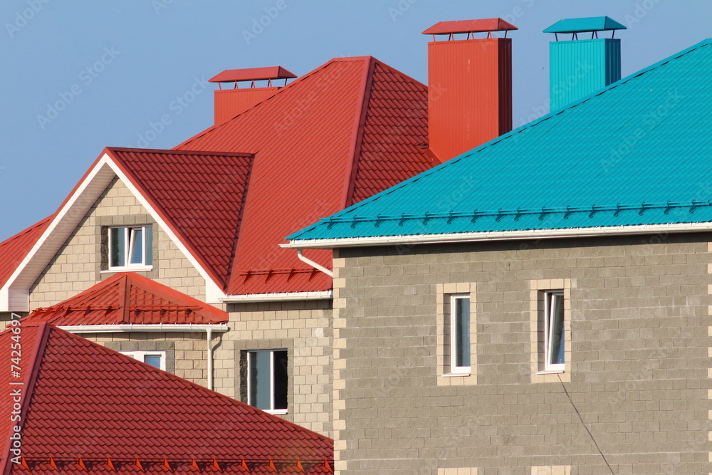Cottages with red and blue roofs against a blue sky