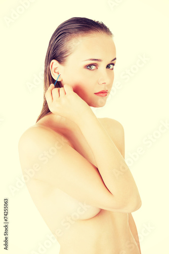 Quadro su tela Woman face closeup while cleaning up an ear with a swab