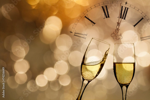 Glasses with champagne and clock close to midnight