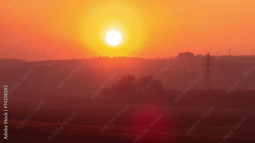 The sunset (sunrise) above the field and electricity pylons The sunset (sunrise) above the field and electricity pylons