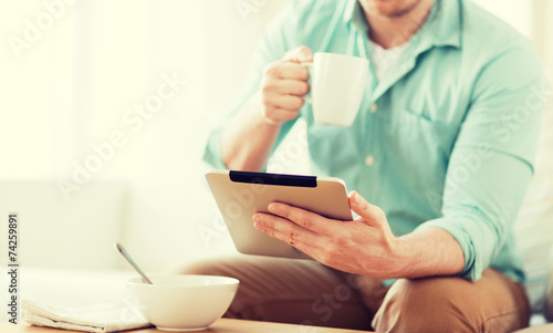 close up of man with tablet pc having breakfast