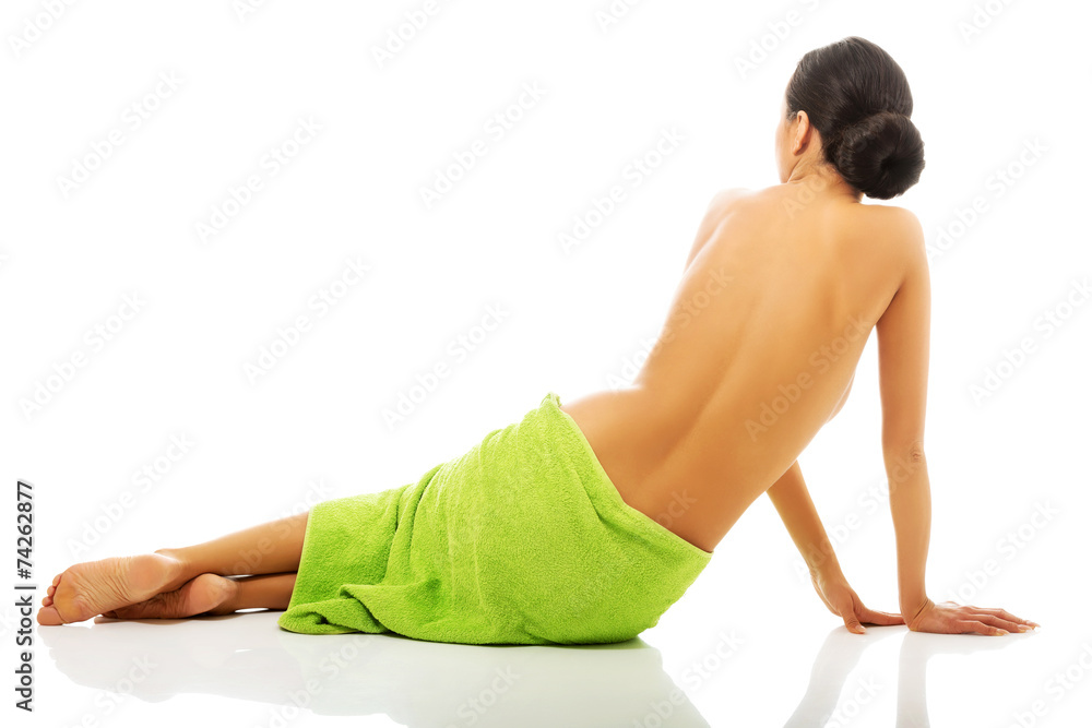 Back view woman sitting wrapped in towel Back view woman sitting wrapped in towel