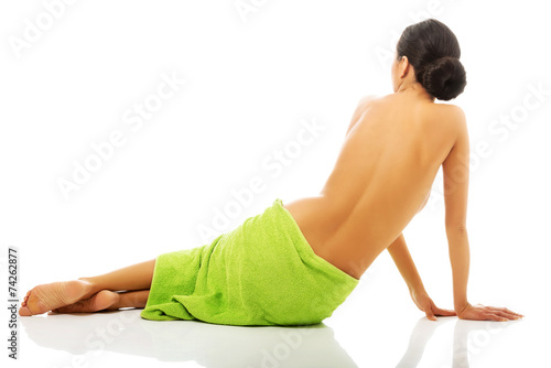 Back view woman sitting wrapped in towel