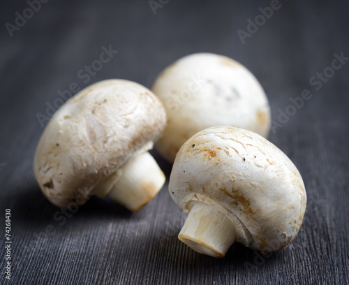 Fresh champignons on black wooden board