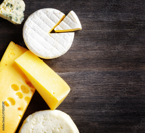 Different types of cheese on a wooden board photo