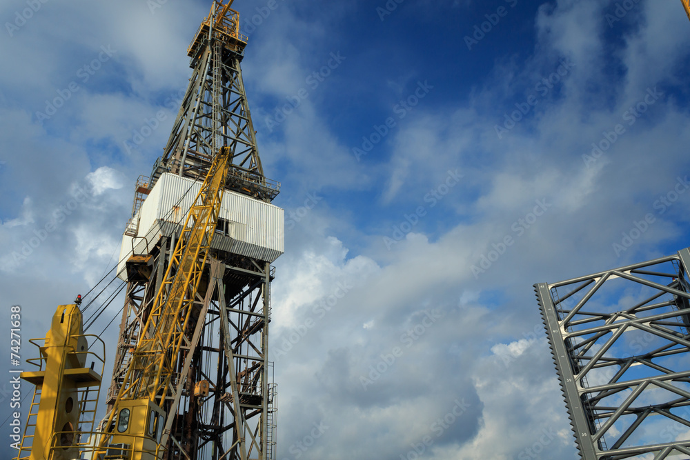 Offshore Drilling Rig with Working Cranes on Cloudy Day