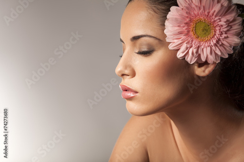 Profile of young beautiful young woman with gerbera
