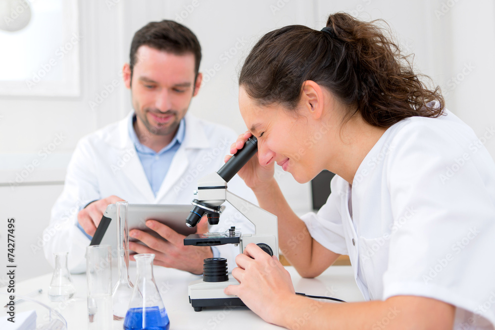 Scientist and his assistant in a laboratory Scientist and his assistant in a laboratory