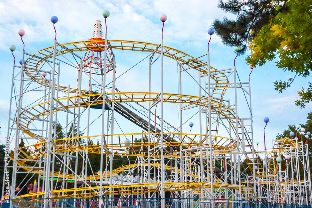 Obraz premium Rollercoaster in the evening against blue sky.