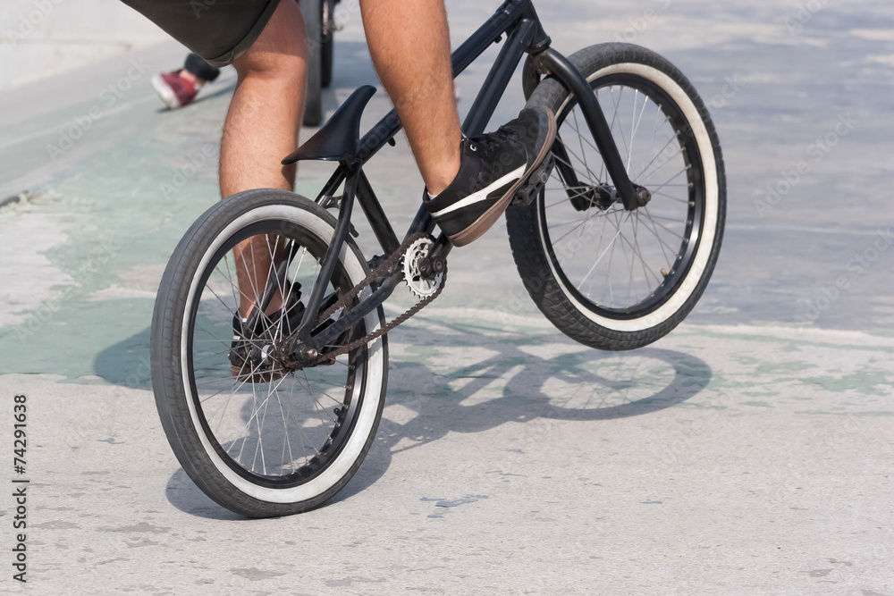 Young boy doing a trick with his BMX bike near ramps Young boy doing a trick with his BMX bike near ramps