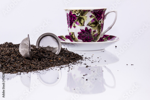 Cup and black tea on white background.