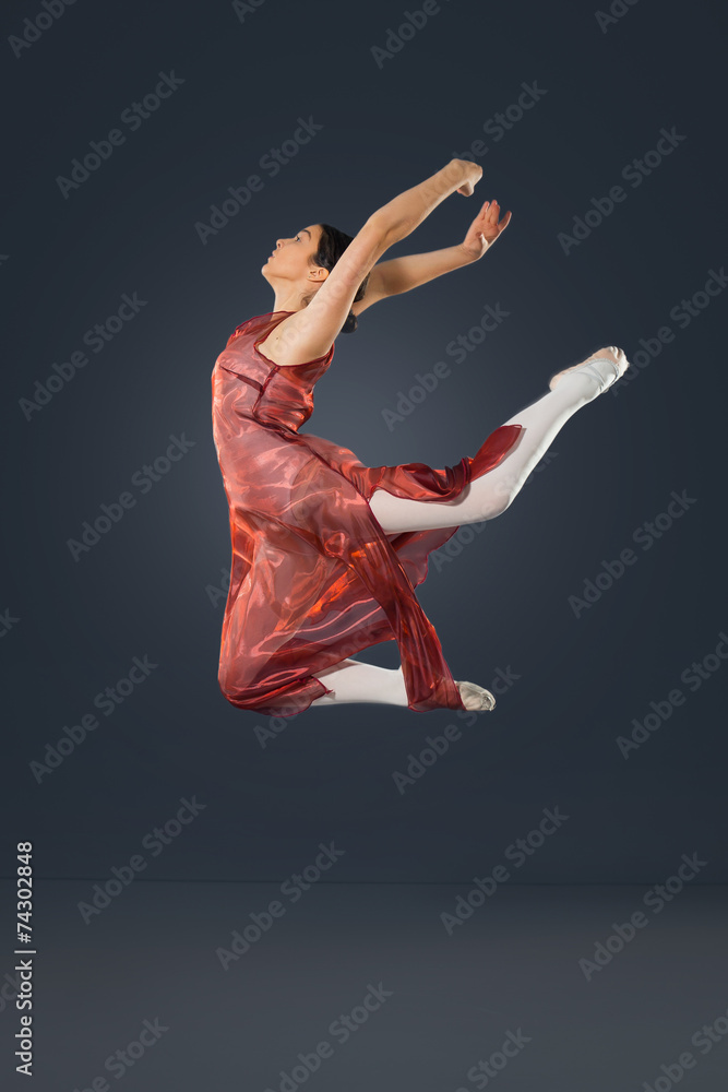 Beautiful female ballet dancer on a grey background.
