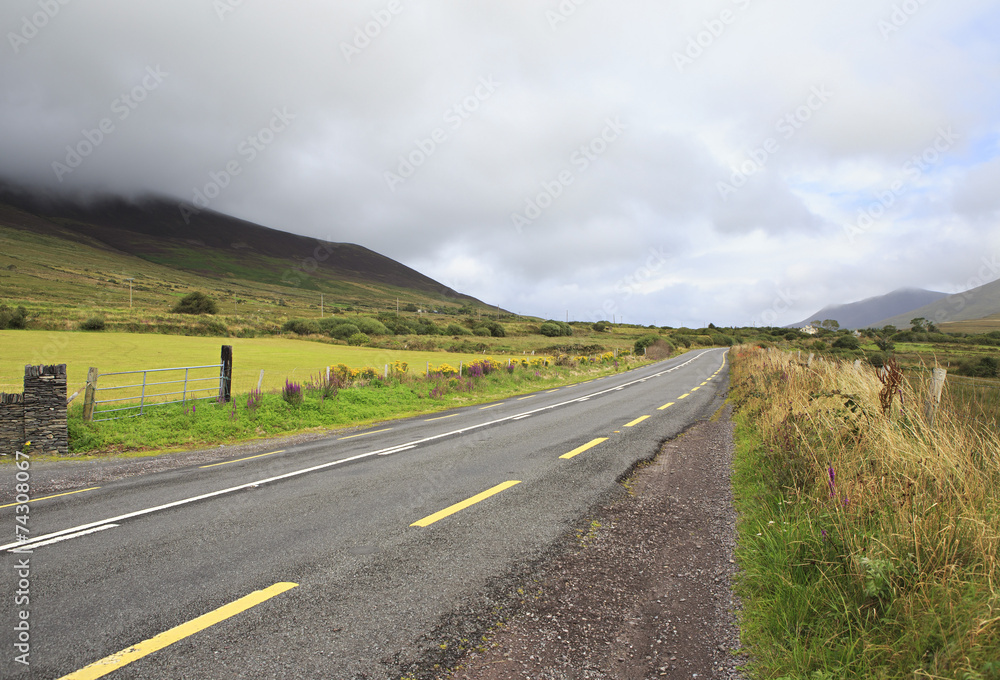 Fototapeta premium Road with clouds on the hills.