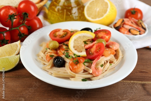 Tasty pasta with shrimps, mussels, black olives and tomato