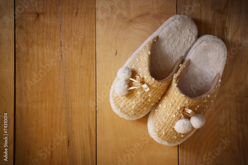 top view of warm woman slippers over wooden floor