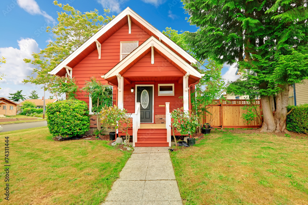 Small coutnryside house exterior in bright red color with white