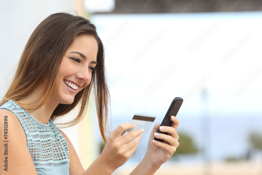 Happy woman buying online with a smart phone Happy woman buying online with a smart phone