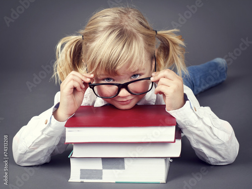 Adorable little girl wearing glasses and  holding books photo