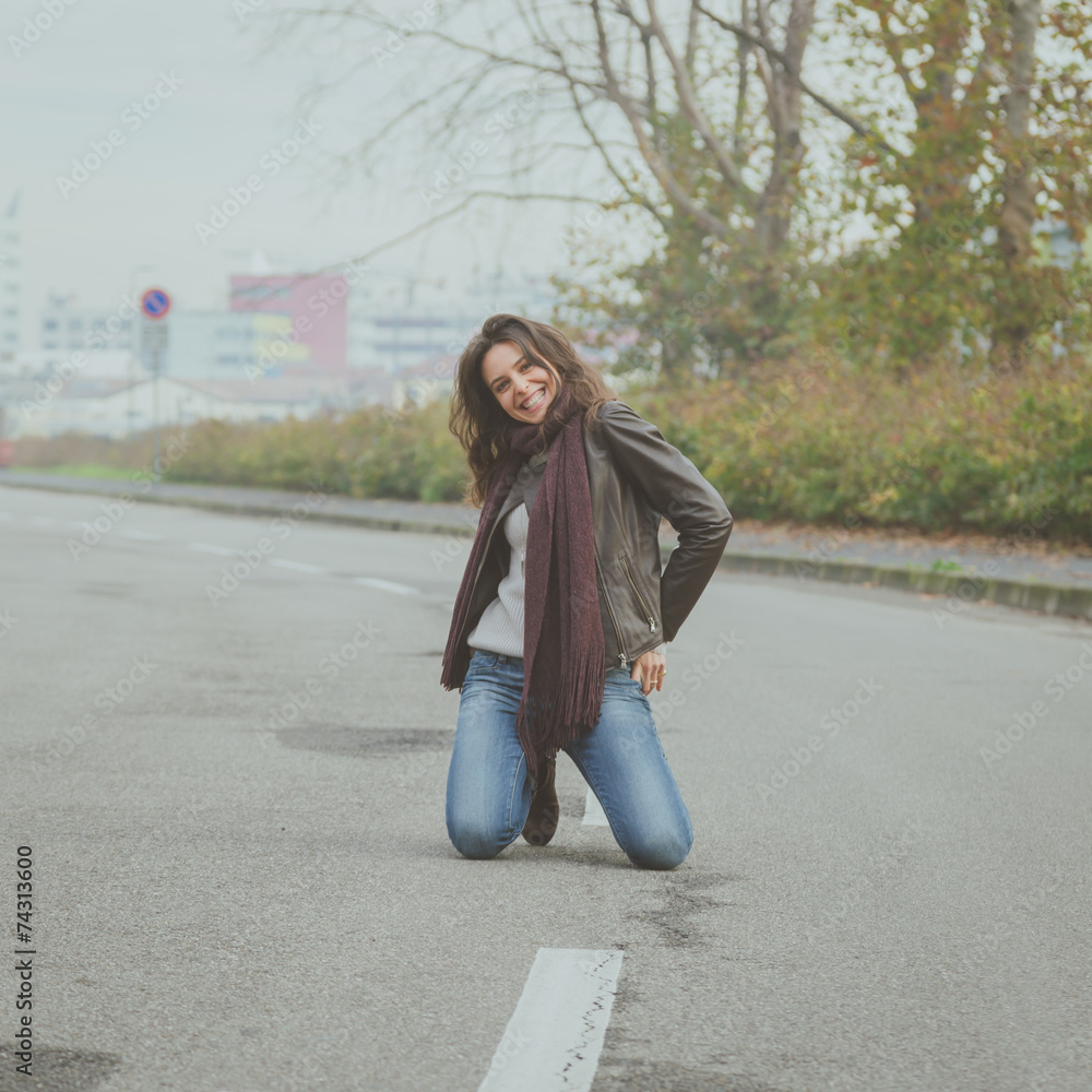 Fototapeta premium Beautiful young brunette posing in the city streets