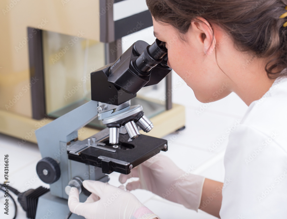female student looking into the microscope female student looking into the microscope