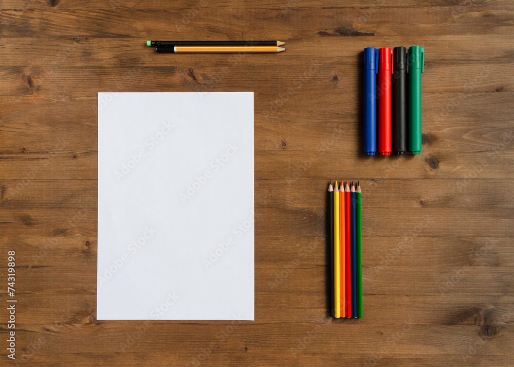 Obraz premium sheet of paper, colored markers and pencils on old wooden table