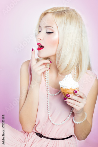 woman sitting with a cupcake and licks sweet cream