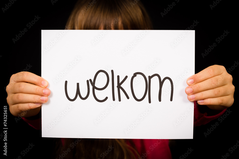 Child holding sign with Dutch word Welkom - Welcome Child holding sign with Dutch word Welkom - Welcome