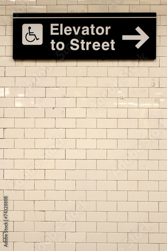 New York City Station subway directional sign on tile wall.