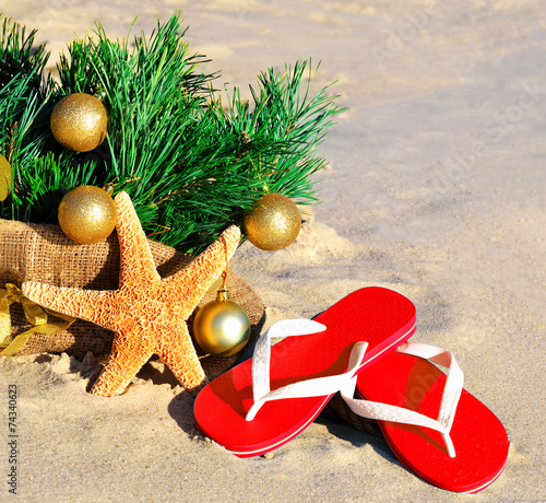 Christmas tree with christmas balls, slippers and starfish on th