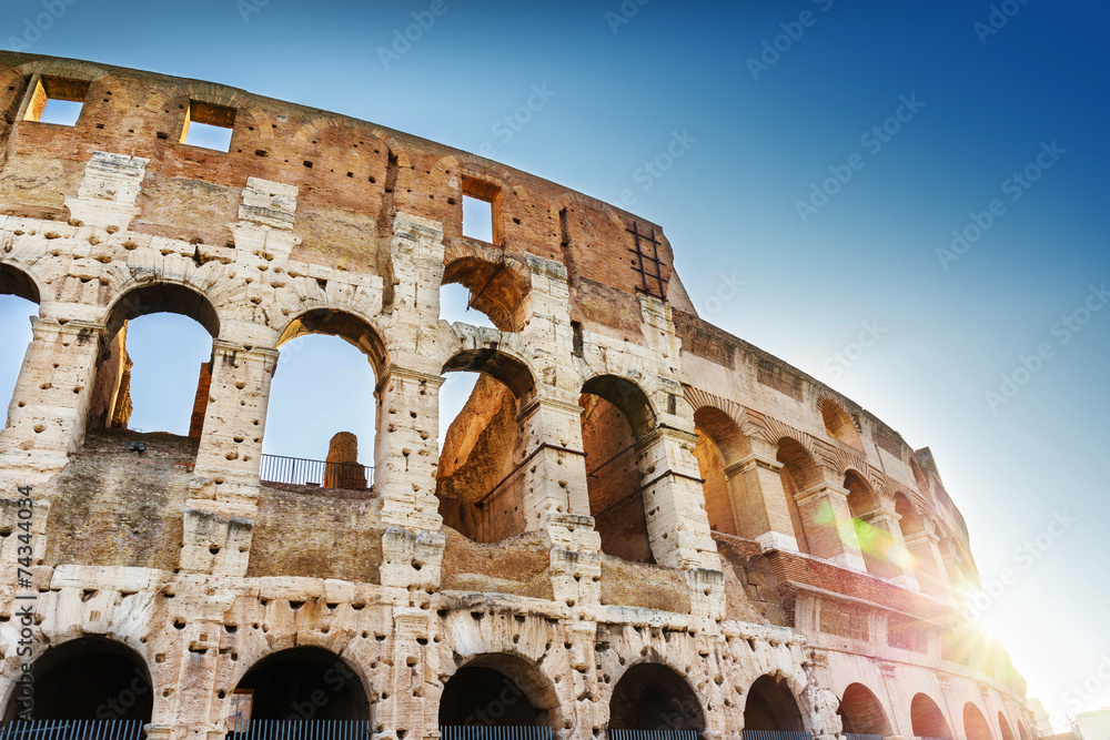 Close-up details of Colosseum with sunbeams. Rome, Italy