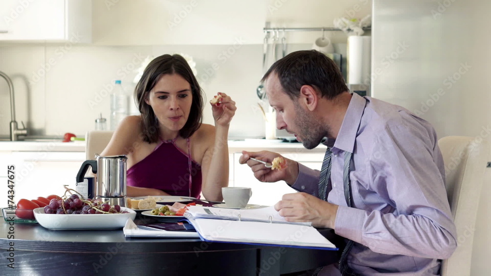 Young businessman working with documents during breakfast with h Young businessman working with documents during breakfast with h