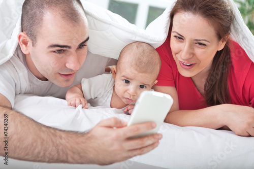 Adorable smiling family using mobile at home