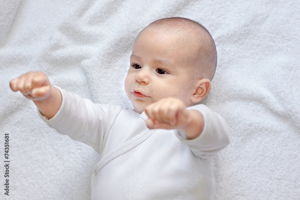 Strong healthy baby looking at fists Strong healthy baby looking at fists
