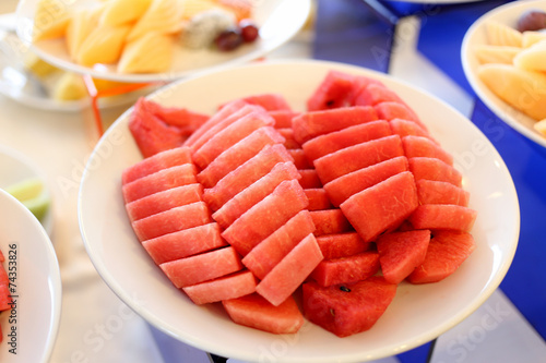 Watermelon cut in pieces in white dish.