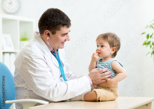 pediatrician examining hear...