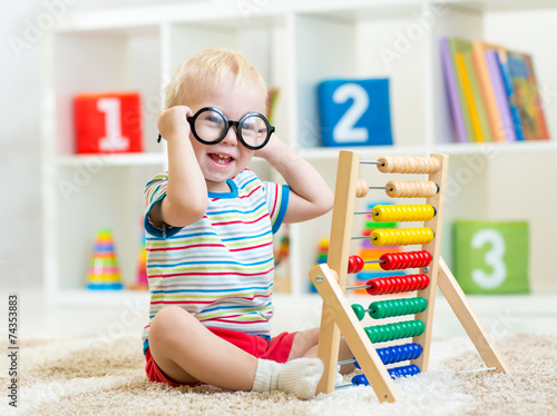 child with eyeglasses playi...
