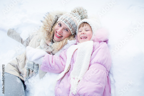 Happy mother and child have fun on snow in winter outdoor