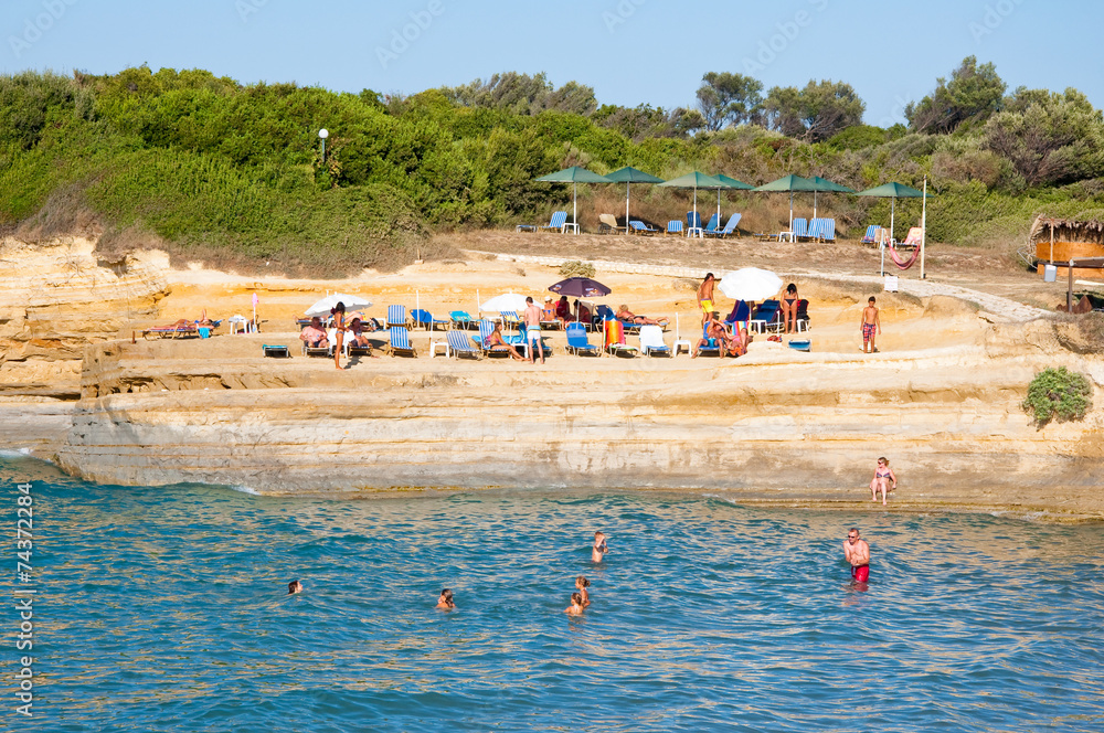 Sidary beach, people sunbath on the sandy shore.Corfu, Greece.
