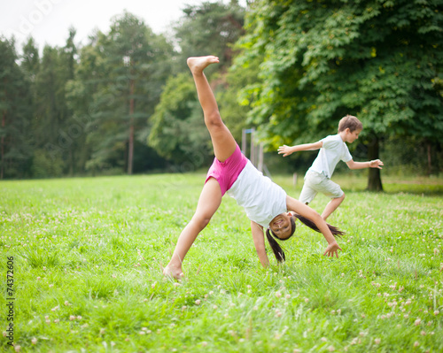 Bruder und Schwester schagen Rad auf der Wiese