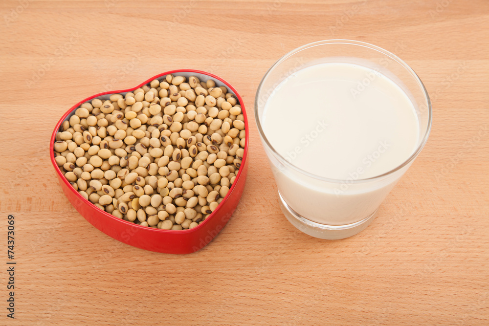 Soy milk in glass with soybeans in heart shape box