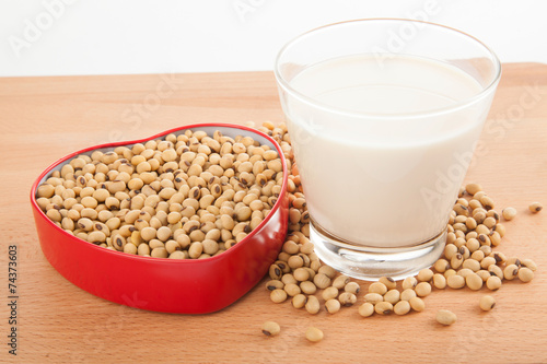 Soy milk in glass with soybeans in heart shape box