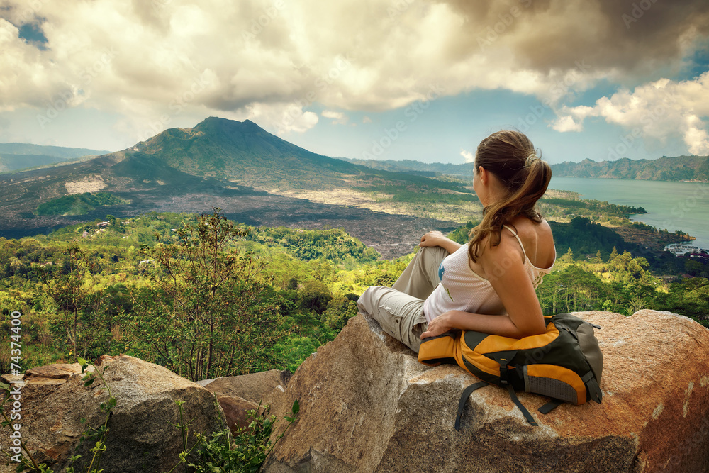 Woman traveler looking at Batur volcano - obrazy, fototapety, plakaty 