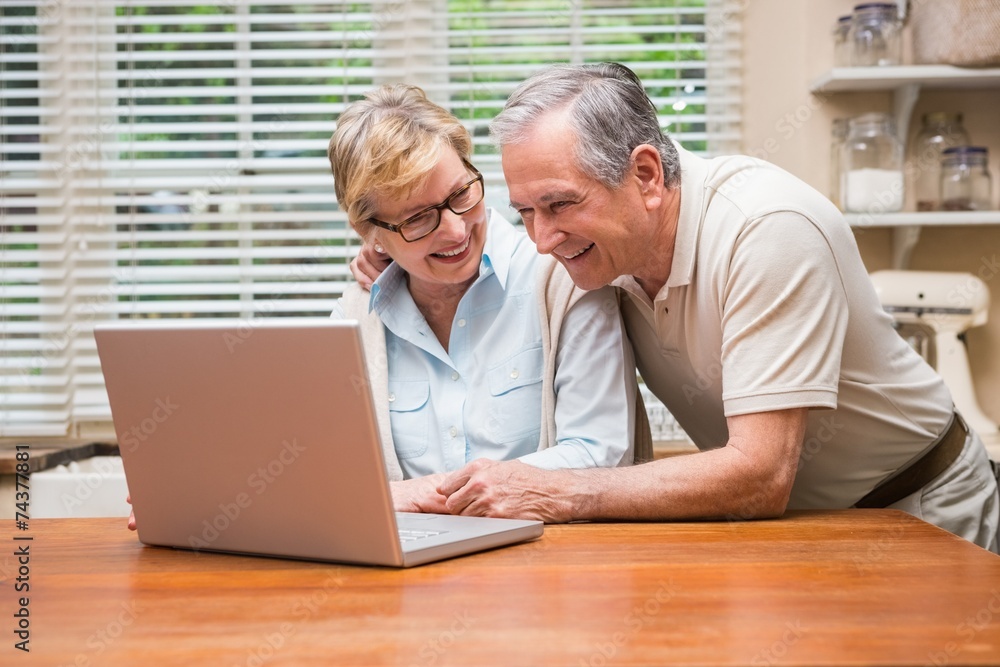 Senior couple using the laptop together Senior couple using the laptop together