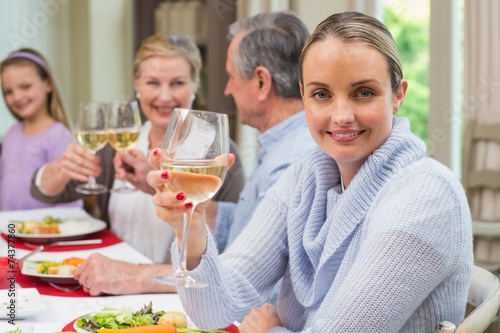 Woman smiling at camera while holding a glass of wine