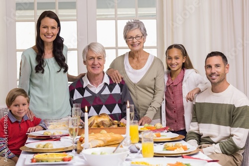 Happy extended family at christmas dinner posing at camera