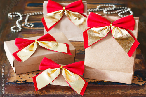 Fényképezés Christmas gifts paper package with red golden bow and chaplet